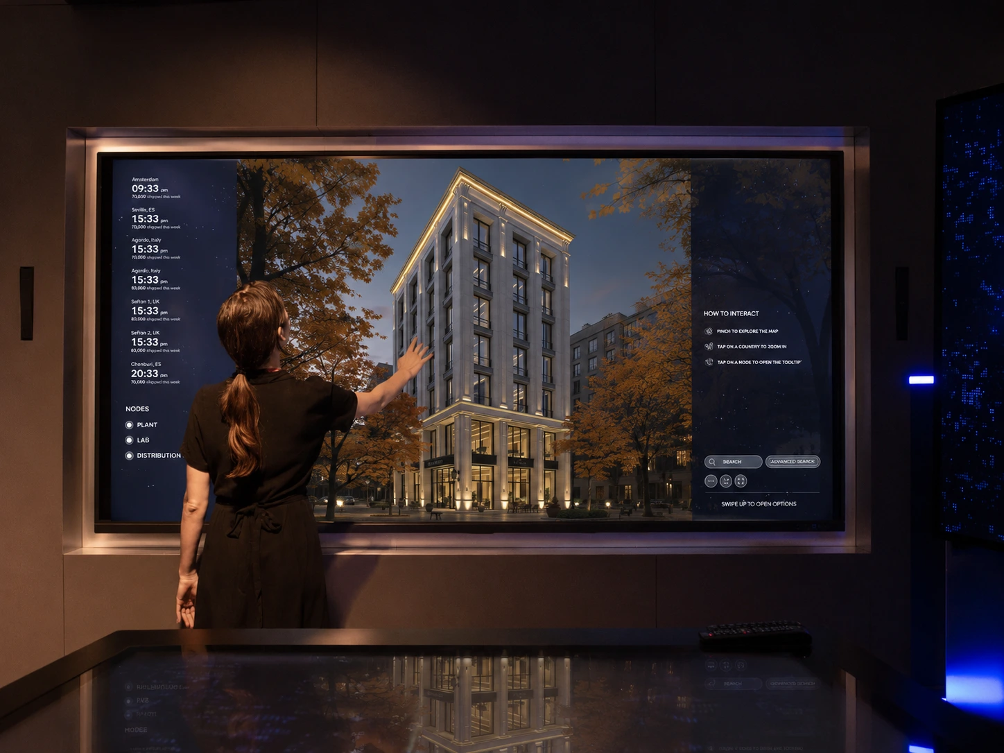 Close-up of a hand touching a large digital display showing a photoreal architectural render of a residential tower — illustrating MetaVyom, Sparrow's interactive digital twin for real estate sales experience centres.